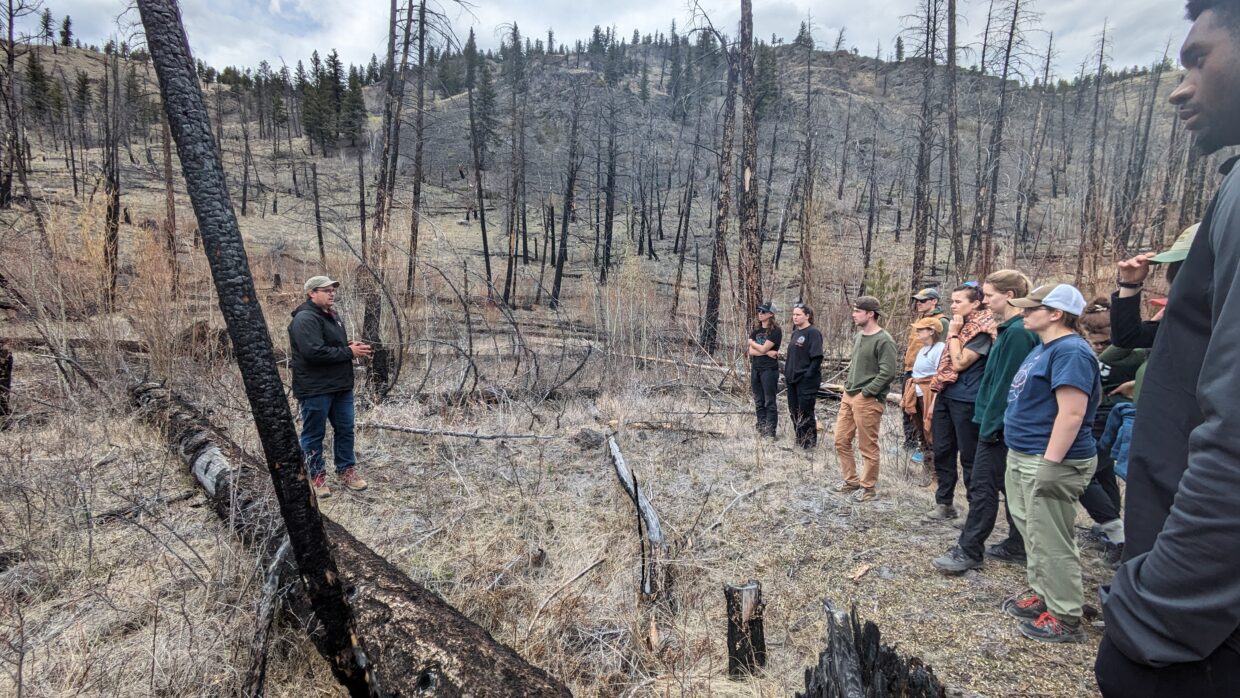 Students from the 2024 field school talk with Shane Dodderidge in a recent wildfire in the Tsilqotin First Nation